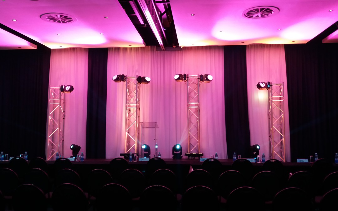Corporate seminar at Lagoon Beach Hotel with navy and white draping lit with pink light by The Events Draping Co. for Network 21.