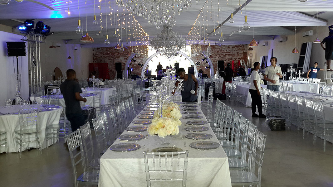 Converted barn event venue with steel roof beams softened by bridal white draping by The Events Draping Co.