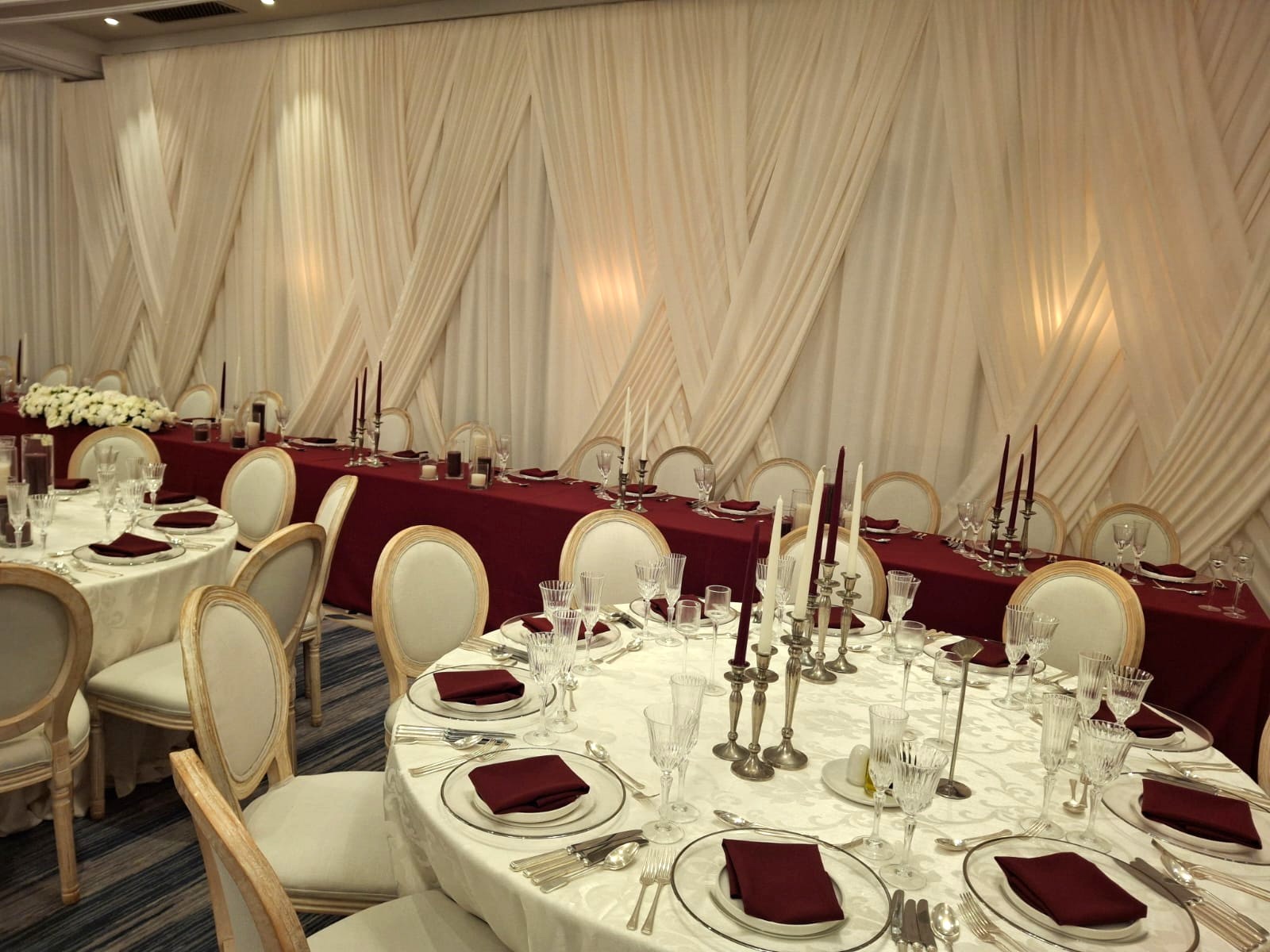 - Cream wall draping with criss-cross overdrapes for a wedding
