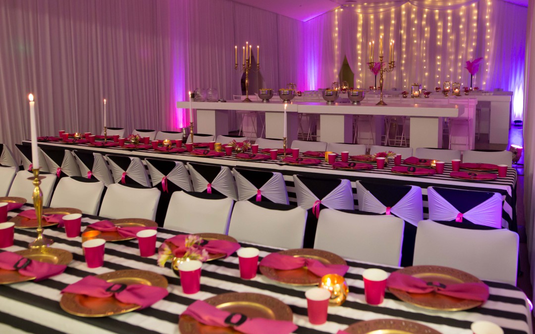 Shocking pink and black & white striped bat mitzvah setup at Atlantic Greenpoint Bowling Club, Cape Town, featuring draped walls and fairy lights by The Events Draping Co.