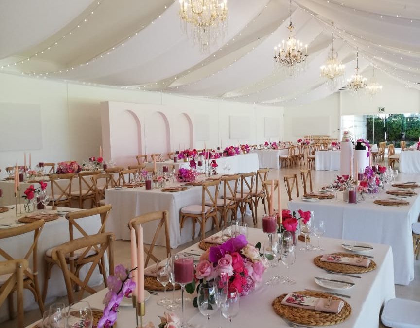Wedding reception setup featuring white ceiling draping with fairy lights and chandeliers by The Events Draping Co.