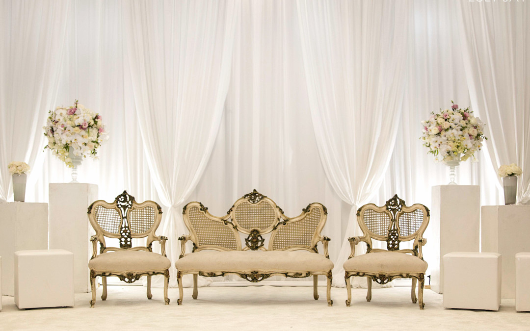Wedding setup at Islamia College banquet hall, featuring a white bridal backdrop and over-drapes by The Events Draping Co.