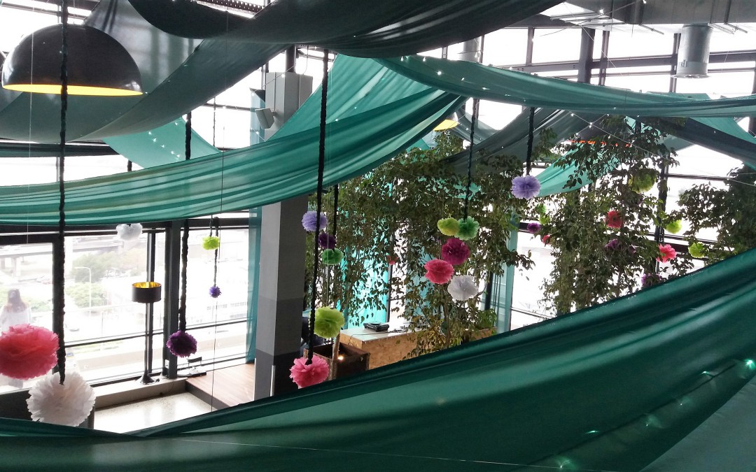 Midnight in the Garden of Good-themed corporate party at 99c, featuring green swags, fairy lights, and colourful flowers by The Events Draping Co.