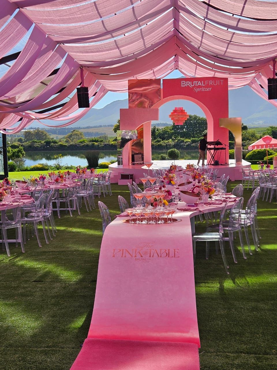 Transparent marquee draped with pink strips by The Events Draping Co.