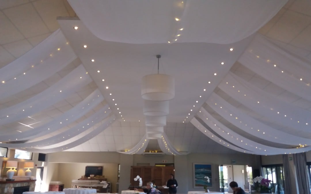 Wedding setup at Cape Point Vineyards Restaurant in Noordhoek, featuring white ceiling strips and fairy lights by The Events Draping Co.