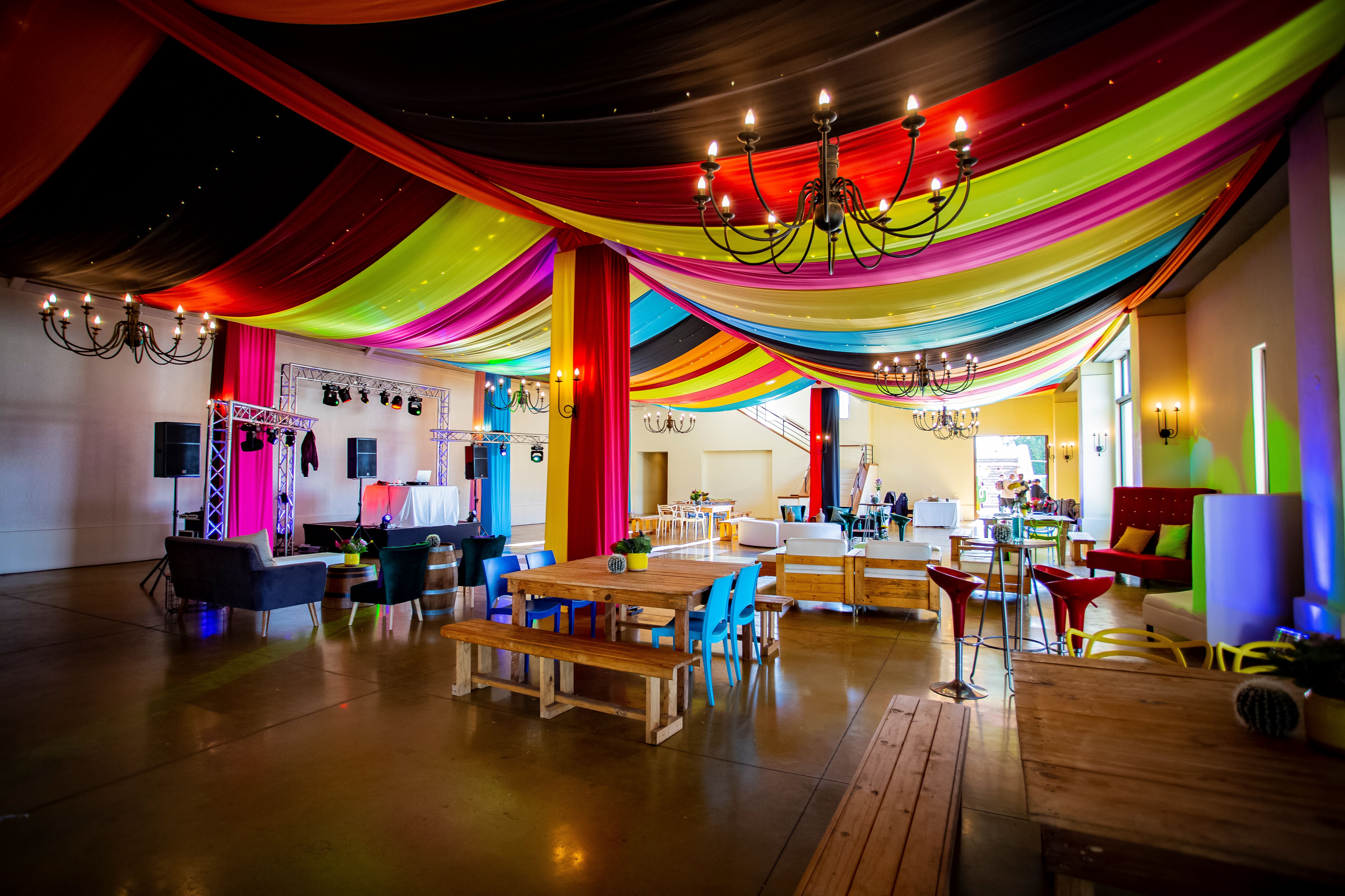 Fully draped ceilings and pillars in multi-coloured fabric for a Mexican-themed event by The Events Draping Co.