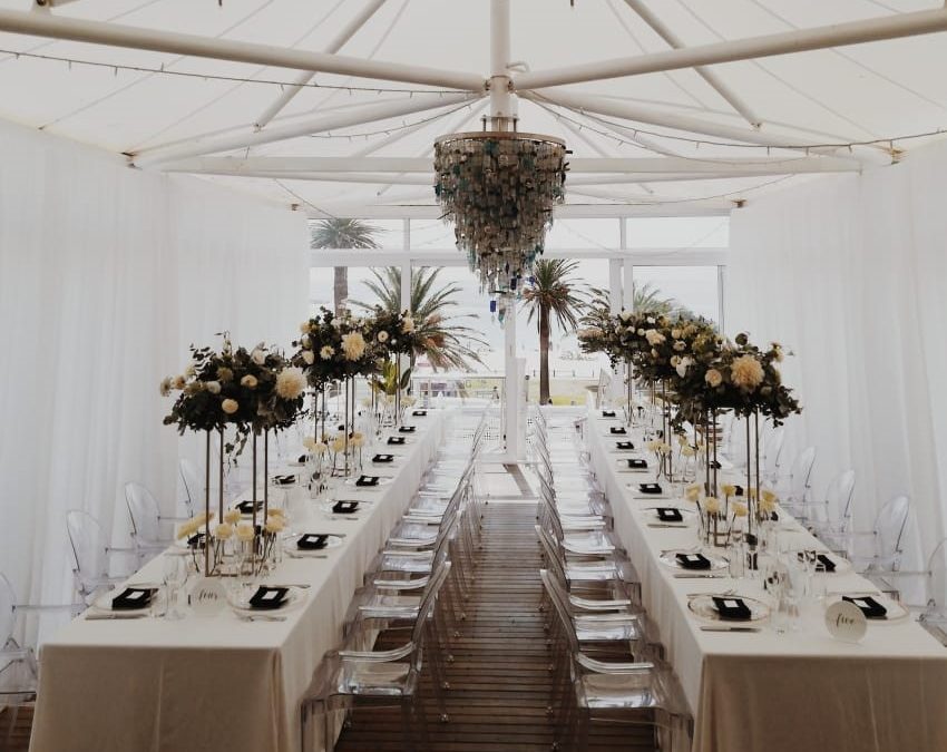 Elegant dining setup with white draping and floral arrangements by The Events Draping Co.