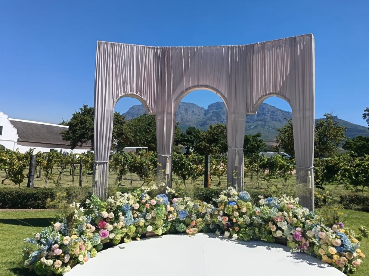 Triple wedding arch draped in dusty pink fabric by The Events Draping Co.