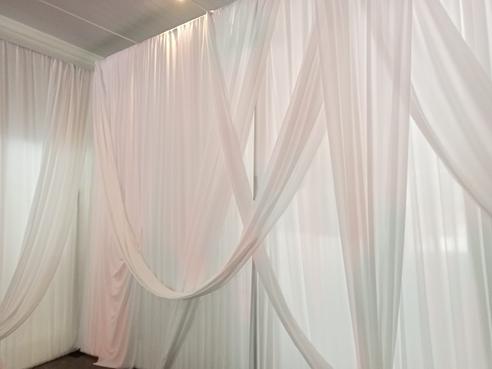 White wall draping with random swag overlays and tiebacks by The Events Draping Co.