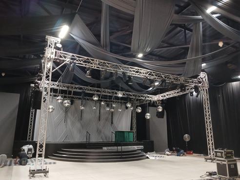 Large stage setup with white draping by The Events Draping Co., creating a dramatic event atmosphere.